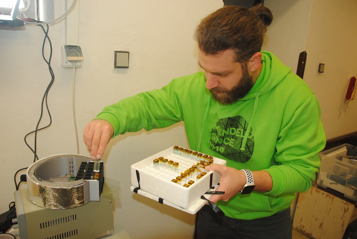 Vedoucí laboratoře Lukáš Nejdl ukládá do modulu vzorky pro fotochemické pokusy.